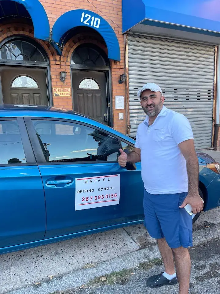 Rafael Salem, founder and lead instructor, next to a Rafael Driving School car